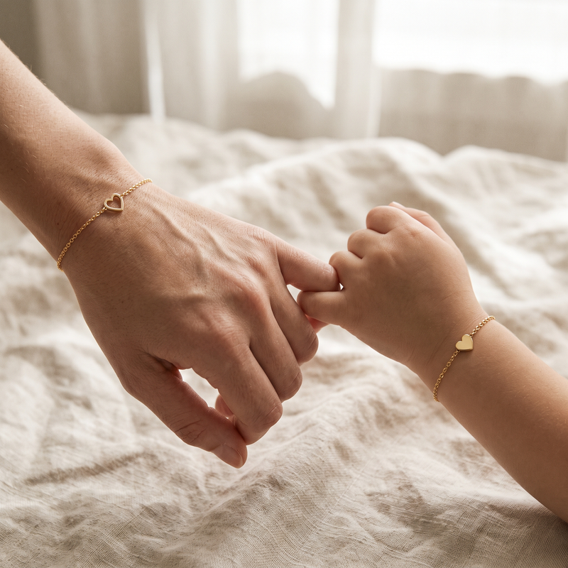 Mamma och dotter krokar lillfingrar med matchande hjärtarmband
